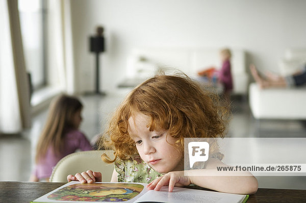 Kleines Mädchen beim Lesen eines Buches  zu Hause
