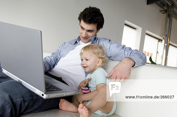 Man and little boy using laptop