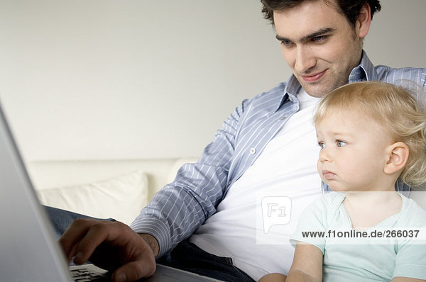 Mann und kleiner Junge mit Laptop
