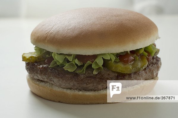 Hamburger mit Gewürzgurke  Salat und Ketchup