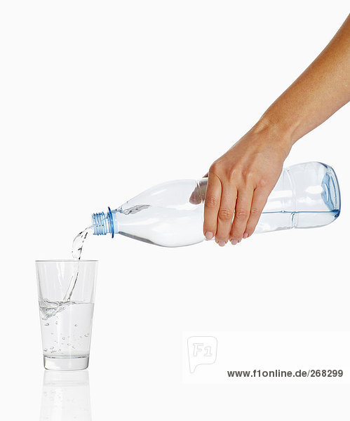 Frauenhand schenkt Wasser ein