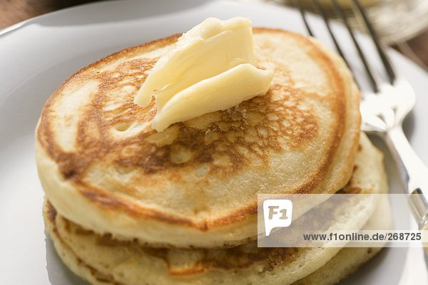 Pancakes mit Butterflocke auf einem Teller