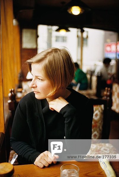 Eine Frau sitzen an einem Tisch in einem Restaurant.
