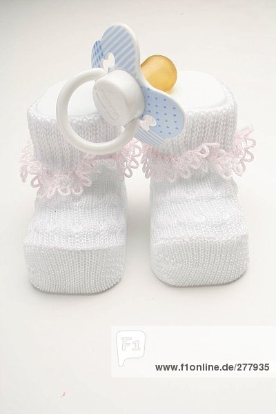 Close-up of pair of baby booties and pacifier