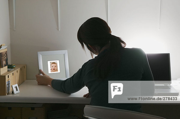 Woman looking at picture of baby