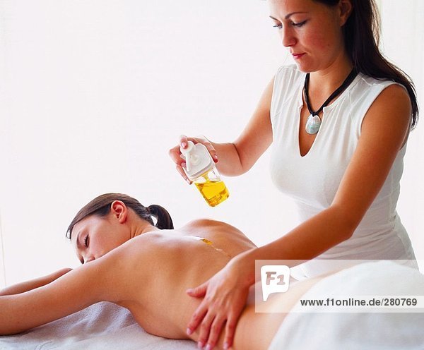 Rückansicht des jungen Frau immer wieder Massage von Massage-Therapeut