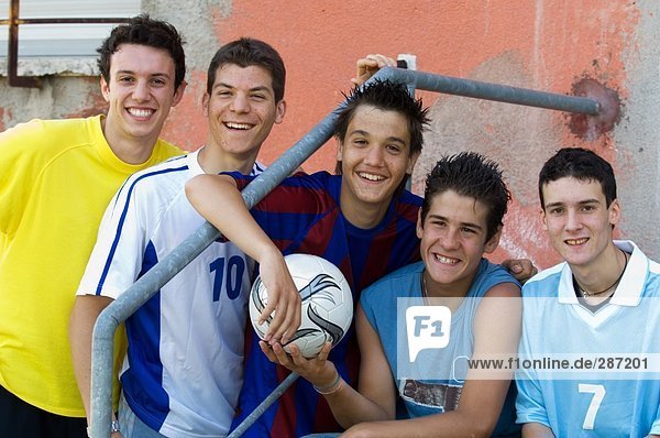 Group of teenage soccer friends on steps