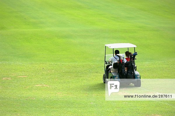 Rückansicht des zwei Golfer sitzen in einem Golf-cart