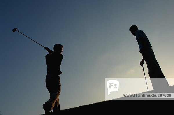 Silhouette eines Mannes in Aktion schlagen eine Golf erschossen