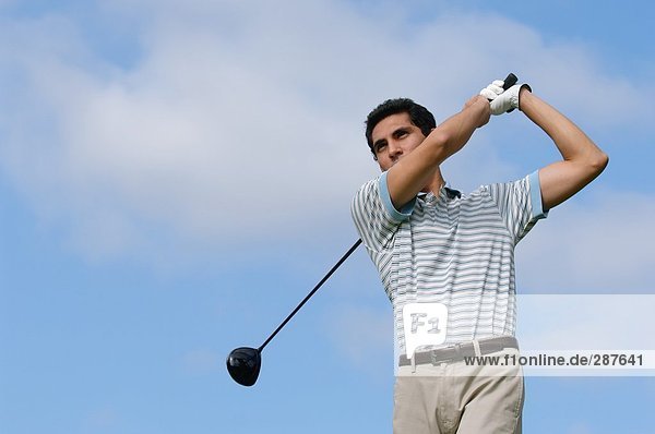 Junger Mann spielt Golf