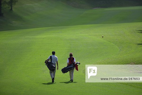 Paar geht hinunter Wiederschiffbarmachung der ein Golfplatz