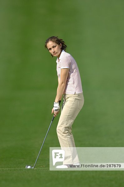 Junge weibliche Golfer Vorbereitung für einen Golf-Schuss