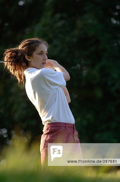 Weibliche Golfer einen Golfschläger geschwungen