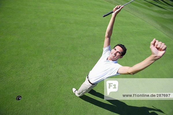 Männlichen Golfspieler feiert eine erfolgreiche Putt