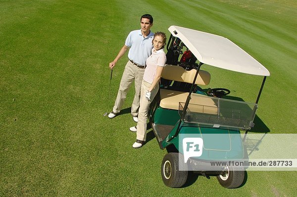 Paar Standing in der Nähe ein Golf-cart