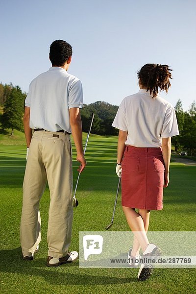 Rear view of a couple viewing the golf course