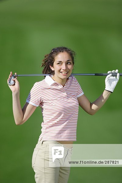 Frau posieren an die Kamera hält einen Golf club
