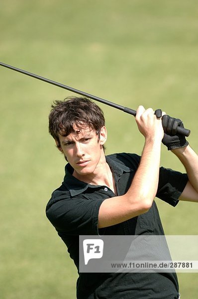 Portrait of a man playing a golf stroke