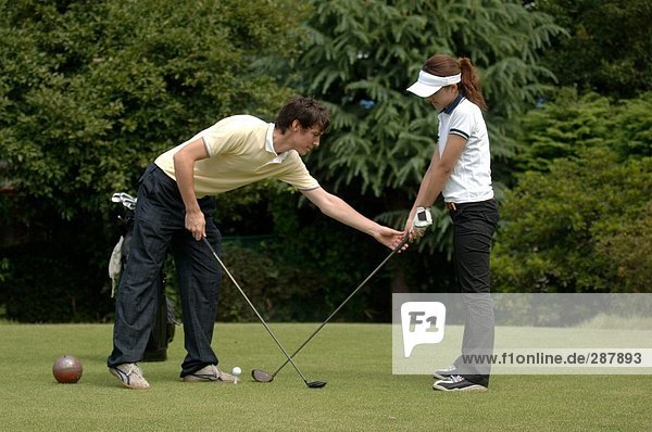 Mann Lehre eine Frau Golf zu spielen
