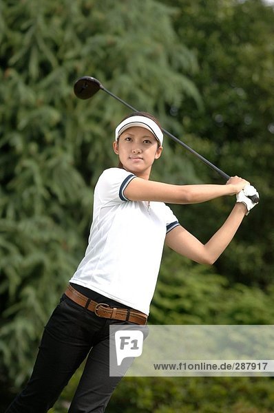 Front view of a woman playing a golf stroke