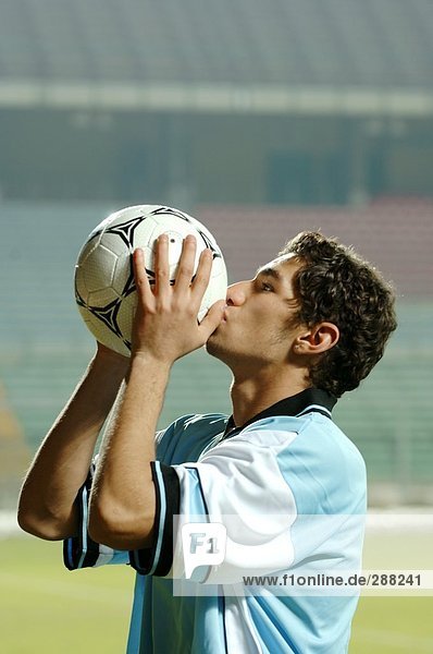 Soccer Player Kissing a Soccer Ball