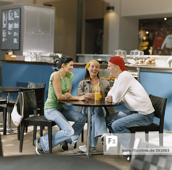 Three people in a cafe.