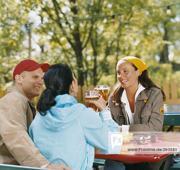 Drei Freunde in ein open-air-Restaurant.