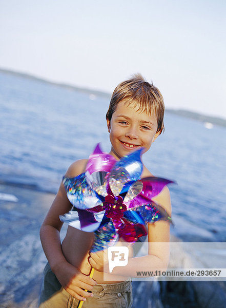 Ein Junge am Meer halten ein Spinning Toy.