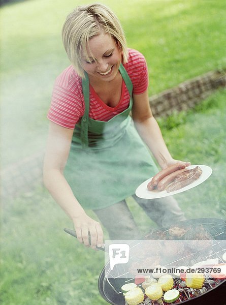 A woman by a grill.