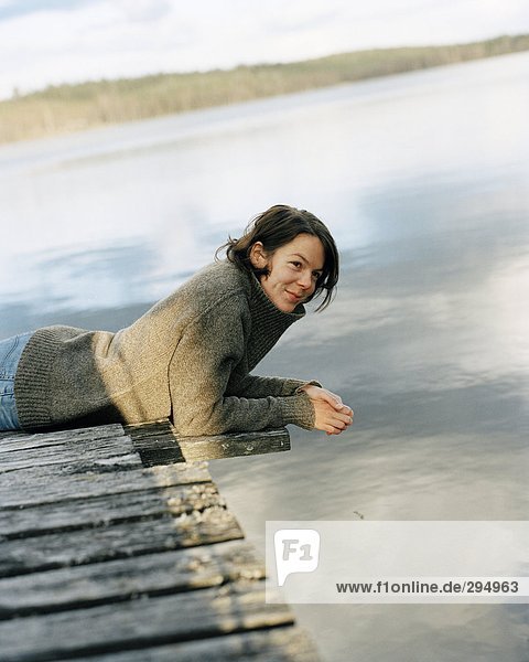 Eine Frau liegend auf einer Brücke.
