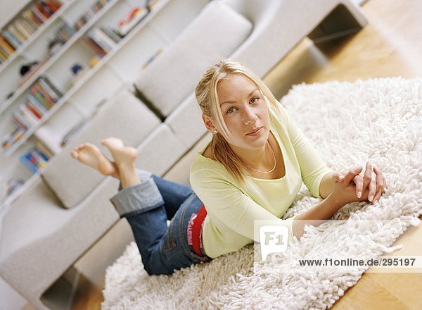 liegend liegen liegt liegendes liegender liegende daliegen Frau sehen Blick in die Kamera Teppichboden Teppich Teppiche