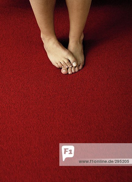 Nackte Füße auf einer roten Matte.