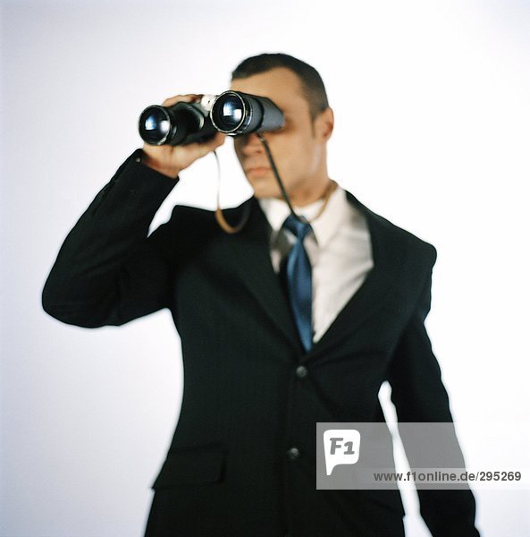 A man looking in a pair of binoculars.