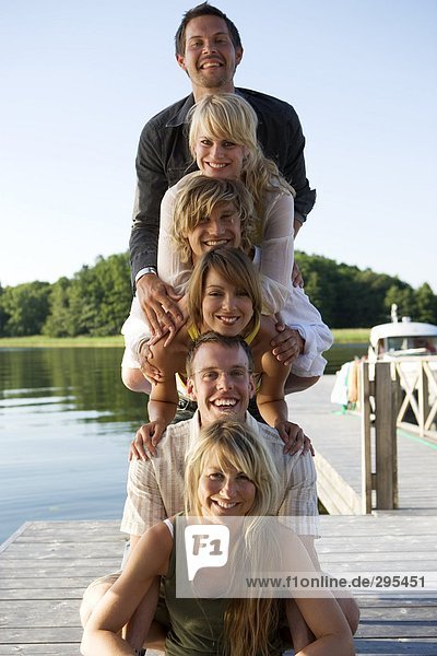 Sechs Menschen Lächeln in die Kamera auf einer Brücke.