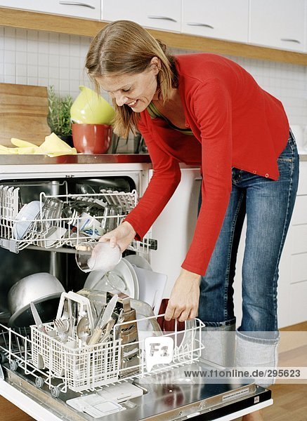 Eine Frau setzen Gerichte in einer Spülmaschine.