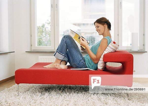 Eine Frau in einem Sofa lesen.