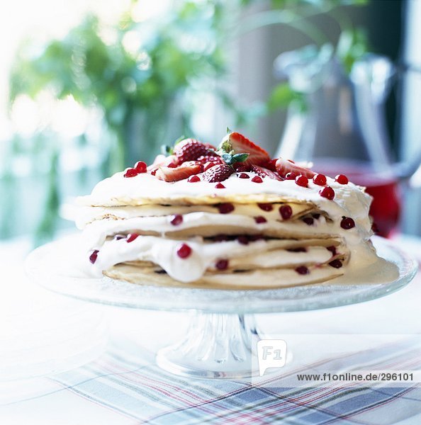 Ein Kuchen  hergestellt aus Palatschinken mit Erdbeeren und verschiedenen Beeren Nahaufnahme.