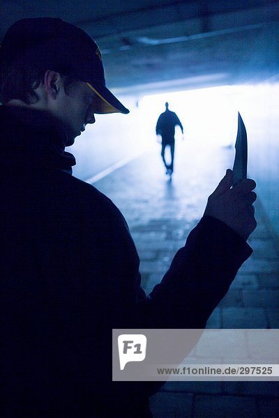 Ein Mann mit einem Messer in einem Viadukt.