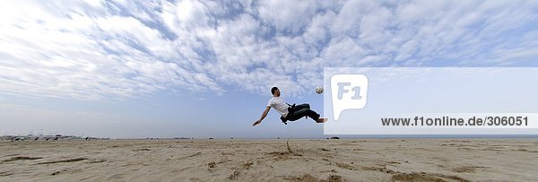 Man Playing Soccer On Beach