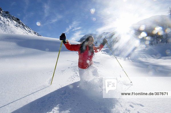 Junge Frau beim Skifahren in den Bergen  lächelnd