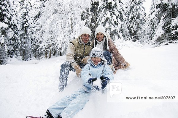 Österreich  Salzburger Land  Junge (6-7) mit Familie im Schnee