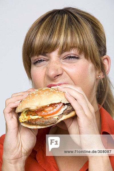 Junge Frau isst Hamburger
