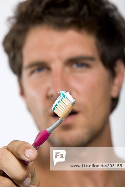 Young man holding tooth brush  portrait