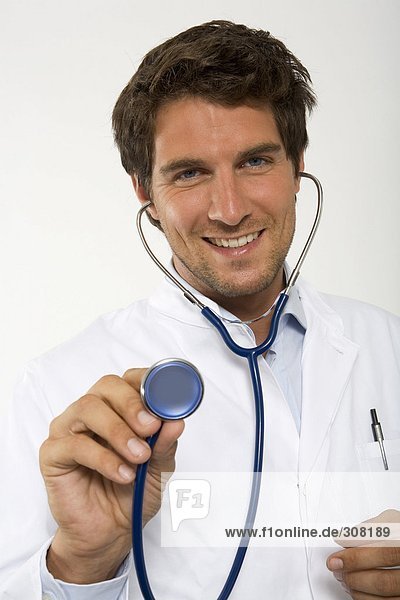 Male doctor holding stethoscope  close-up  portrait
