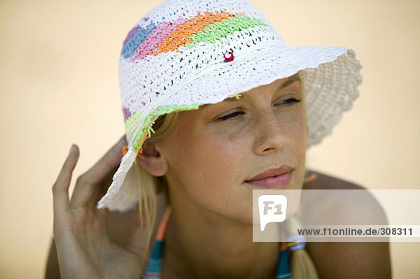 Junge Frau am Strand  mit Hut  Portrait