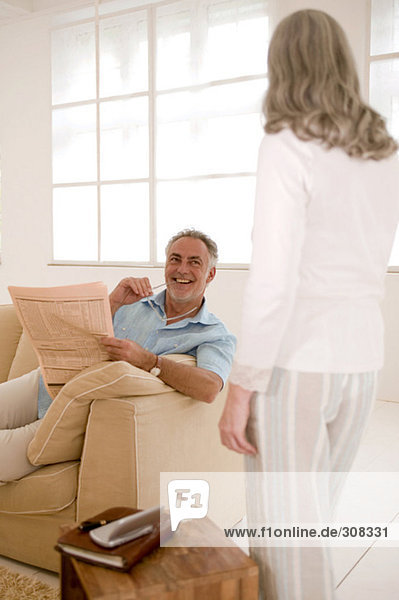 Mature couple in living room  man looking at woman  smiling