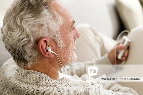 Mature man listening to MP3 player  close-up