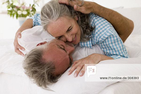 Erwachsenes Paar im Bett umarmend  Nahaufnahme