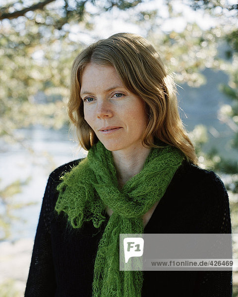 Portrait einer Frau trägt einen grünen Schal.