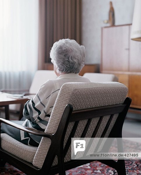 Senior woman sitting in chair  rear view